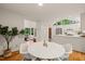 Dining area with a white round table, modern chairs, and views of the living area and kitchen at 1213 Blackwood Mountain Rd, Chapel Hill, NC 27516