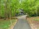 View of the house from the driveway nestled amongst the trees at 1213 Blackwood Mountain Rd, Chapel Hill, NC 27516