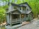 Charming two-story home featuring a welcoming front porch, natural landscaping, and unique architectural details at 1213 Blackwood Mountain Rd, Chapel Hill, NC 27516