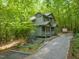 Inviting home with lush landscaping, mature trees, and a driveway leading to a serene, wooded setting at 1213 Blackwood Mountain Rd, Chapel Hill, NC 27516