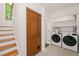 Laundry room features a washer and dryer set, stairs, a storage closet, and shelving for optimal convenience at 1213 Blackwood Mountain Rd, Chapel Hill, NC 27516