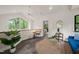Bright living room with large windows offering beautiful outdoor views and a ceiling fan at 1213 Blackwood Mountain Rd, Chapel Hill, NC 27516