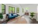 Bright living room with large windows with woodland views, blue sofa and modern furniture at 1213 Blackwood Mountain Rd, Chapel Hill, NC 27516