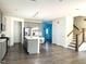 Open-concept living space features gray cabinets, hardwood floors, and stairs leading to the upper level at 1240 Grenshaw Dr, Morrisville, NC 27560