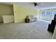 Spacious, sunlit living room featuring neutral carpet, a ceiling fan, and comfortable furniture at 1240 Grenshaw Dr, Morrisville, NC 27560