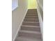 View of carpeted stairs with wooden handrail leading to upper level with light neutral walls at 1240 Grenshaw Dr, Morrisville, NC 27560