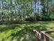 Lush backyard featuring vibrant green grass, mature trees, and wooden landscaping at 125 Occidental Dr, Holly Springs, NC 27540