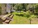 A beautiful backyard with a terraced retaining wall, lush green grass, and mature shade trees at 125 Occidental Dr, Holly Springs, NC 27540