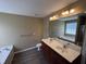 Bathroom boasts double vanity, soaking tub, tile floors, and neutral paint at 125 Occidental Dr, Holly Springs, NC 27540
