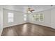 Spacious bedroom featuring three windows, hardwood floors, and neutral-colored walls at 125 Occidental Dr, Holly Springs, NC 27540