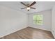 Bright bedroom with hardwood floors, a window, and a modern ceiling fan with a light at 125 Occidental Dr, Holly Springs, NC 27540