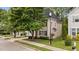 Two-story home with beige siding and black shutters, surrounded by landscaped yard and trees at 125 Occidental Dr, Holly Springs, NC 27540