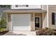 Two-story home featuring beige siding, black shutters, an attached garage, and landscaped yard at 125 Occidental Dr, Holly Springs, NC 27540