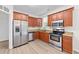 Modern kitchen features stainless steel appliances, granite counters, and wood cabinets at 125 Occidental Dr, Holly Springs, NC 27540