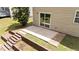 Rear patio, accessed by sliding glass door, with terraced retaining wall and small yard area at 125 Occidental Dr, Holly Springs, NC 27540