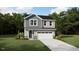 Charming two-story home featuring a gray exterior, complemented by a lush green lawn and a spacious two-car garage at 131 Vulcan St, Garner, NC 27529