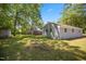Spacious backyard with lush grass, mature trees, and a gray house exterior at 1317 Proctor St, Rocky Mount, NC 27801