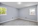 Bright bedroom featuring gray walls, light wood-look floors, and two windows allowing natural light at 1317 Proctor St, Rocky Mount, NC 27801