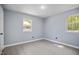 A bright bedroom with gray walls, light wood-look floors and natural light from the two windows at 1317 Proctor St, Rocky Mount, NC 27801