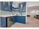 Modern blue wet bar with a beverage fridge and mosaic backsplash at 1632 Ferntree Ct, Morrisville, NC 27560