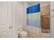 Bathroom showcasing a toilet, tiled shower with blue shower curtain, and a tiled floor at 1632 Ferntree Ct, Morrisville, NC 27560