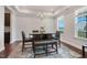Elegant dining area featuring tray ceiling, chandelier, and large windows at 1632 Ferntree Ct, Morrisville, NC 27560