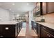 Modern kitchen with dark wood cabinets, stainless steel appliances, and an island with a white countertop at 1632 Ferntree Ct, Morrisville, NC 27560