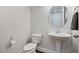 Stylish powder room featuring a pedestal sink, oval mirror, and modern fixtures at 1632 Ferntree Ct, Morrisville, NC 27560