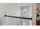 Staircase showcasing a modern chandelier, white banisters, and dark wood handrail at 1632 Ferntree Ct, Morrisville, NC 27560