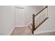 Staircase with carpeted steps and a white and wood railing at 1632 Ferntree Ct, Morrisville, NC 27560