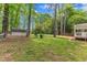 Spacious backyard with a mix of open lawn, mature trees, and a storage shed at 1703 Cranston Road Rd, Garner, NC 27529