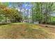A large grassy backyard is surrounded by mature trees, offering both privacy and space at 1703 Cranston Road Rd, Garner, NC 27529