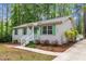 Inviting home exterior with white siding, green shutters, and well-manicured landscaping at 1703 Cranston Road Rd, Garner, NC 27529