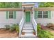 Charming home featuring a bright green front door, complemented by matching shutters and lovely landscaping at 1703 Cranston Road Rd, Garner, NC 27529