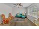 Bright living room featuring a comfortable turquoise sofa, floral chairs, and ample natural light at 1703 Cranston Road Rd, Garner, NC 27529