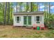 Charming outbuilding with green trim, double doors, and whimsical horseshoe detail surrounded by a lovely wooded backdrop at 1703 Cranston Road Rd, Garner, NC 27529