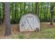 Classic white storage shed with an X-design door nestled among the trees in the backyard at 1703 Cranston Road Rd, Garner, NC 27529