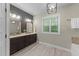 Bright bathroom features double vanity, modern lighting and large window at 179 Carrie Dr, Archer Lodge, NC 27527
