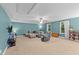 Open bonus room featuring a comfortable sectional, cozy armchair, and natural light from the windows at 179 Carrie Dr, Archer Lodge, NC 27527