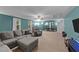 Spacious bonus room showcasing a sectional, game table, and abundant natural light at 179 Carrie Dr, Archer Lodge, NC 27527