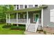 Inviting front porch featuring a teal door, white railings, and decorative hanging plants at 179 Carrie Dr, Archer Lodge, NC 27527