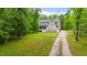 Spacious front yard showcasing a well-maintained lawn, mature trees, and long gravel driveway at 179 Carrie Dr, Archer Lodge, NC 27527