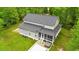 Aerial view of the home's rear showing the gray siding, screened porch, hot tub, and lush lawn at 179 Carrie Dr, Archer Lodge, NC 27527
