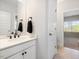 Stylish bathroom featuring a white vanity with black hardware, a modern mirror, and a view of the bedroom at 1824 Amberly Ledge Way, Cary, NC 27519