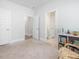 Neutral bedroom with three entryways and a bookcase featuring books and toys at 1824 Amberly Ledge Way, Cary, NC 27519