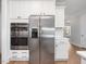 Stainless steel appliances: refrigerator, ovens and white cabinets adding appeal and functionality to the well-designed kitchen at 1824 Amberly Ledge Way, Cary, NC 27519
