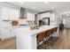 Bright kitchen featuring an island with bar seating, quartz countertops, stainless steel appliances, and white cabinetry at 1824 Amberly Ledge Way, Cary, NC 27519