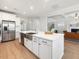 Kitchen island with quartz countertops, stainless steel sink, dishwasher and view of the open-concept living spaces at 1824 Amberly Ledge Way, Cary, NC 27519
