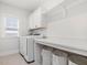 Well-organized laundry room featuring white cabinets, shelving, and modern washer and dryer at 1824 Amberly Ledge Way, Cary, NC 27519