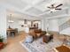 Open-concept living room with coffered ceilings flowing into a bright kitchen with an island and stainless steel appliances at 1824 Amberly Ledge Way, Cary, NC 27519